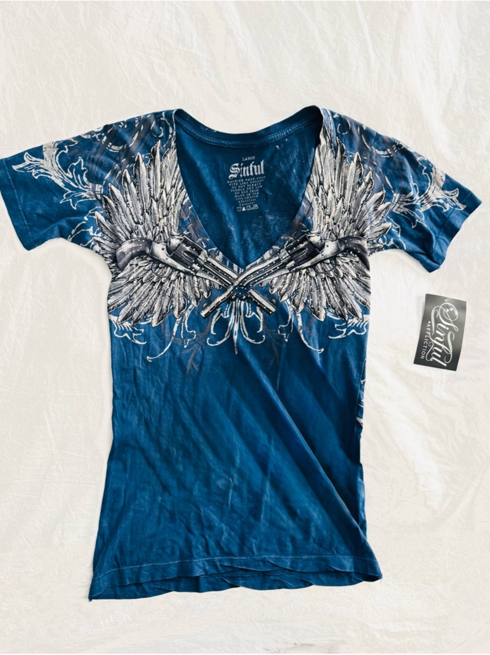 Sinful by Affliction V-Neck 
Blue & White Winged Guns with Rhinestones